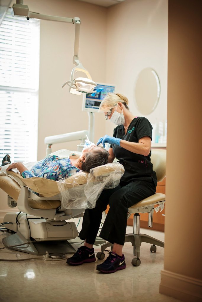 dental hygienist working on patient in chair