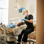 dental hygienist working on patient in chair
