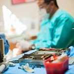 Dr. Bocanegra attending to patient with a tray of dental tools next to him