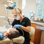 {PRACTICE_NAME} Dental Hygienist attending to patient