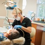{PRACTICE_NAME} Dental Hygienist attending to patient